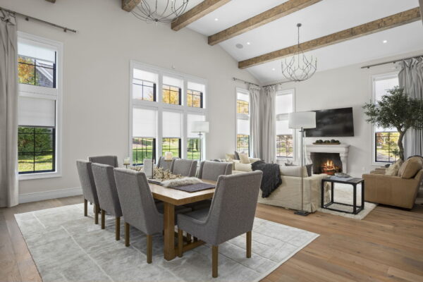 An open concept dining room and living room with upholstered dining chairs and neutral finishes.
