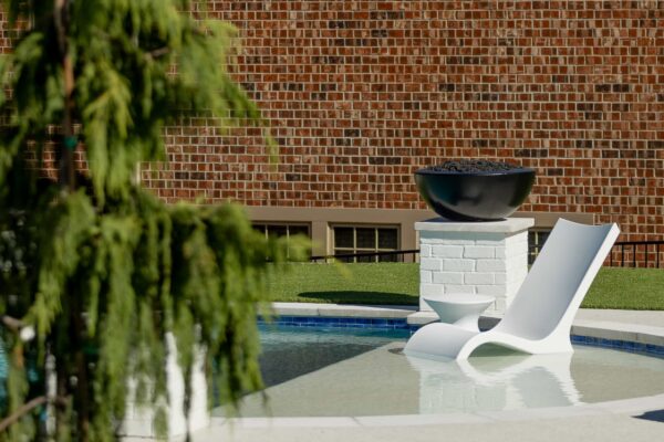 An outdoor lounge chair and matching side table sit on a Baja shelf.