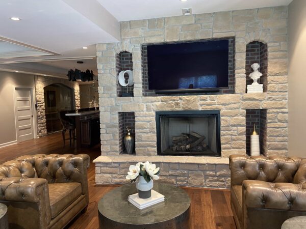 A stone fireplace wall with niches for a TV and decor.