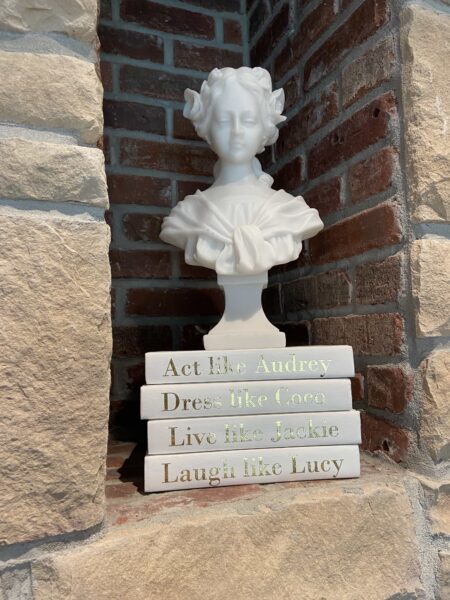 A white bust sits on top of a stack of books.