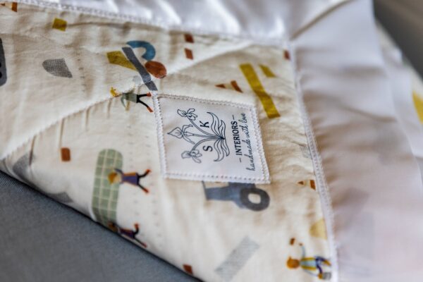 The SK Interiors logo sewn into a handmade quilt.