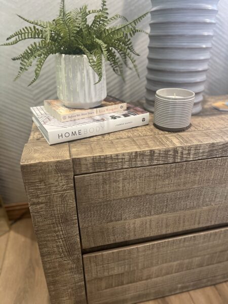 Reclaimed oak sideboard displaying a fern in a white fluted planter placed on top of a stack of books.